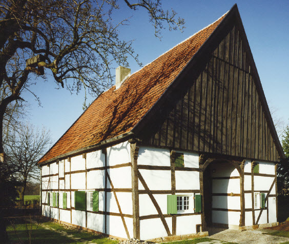 Historisches Fachwerkhaus mit weiß verputzten Gefachen und steilem Ziegeldach